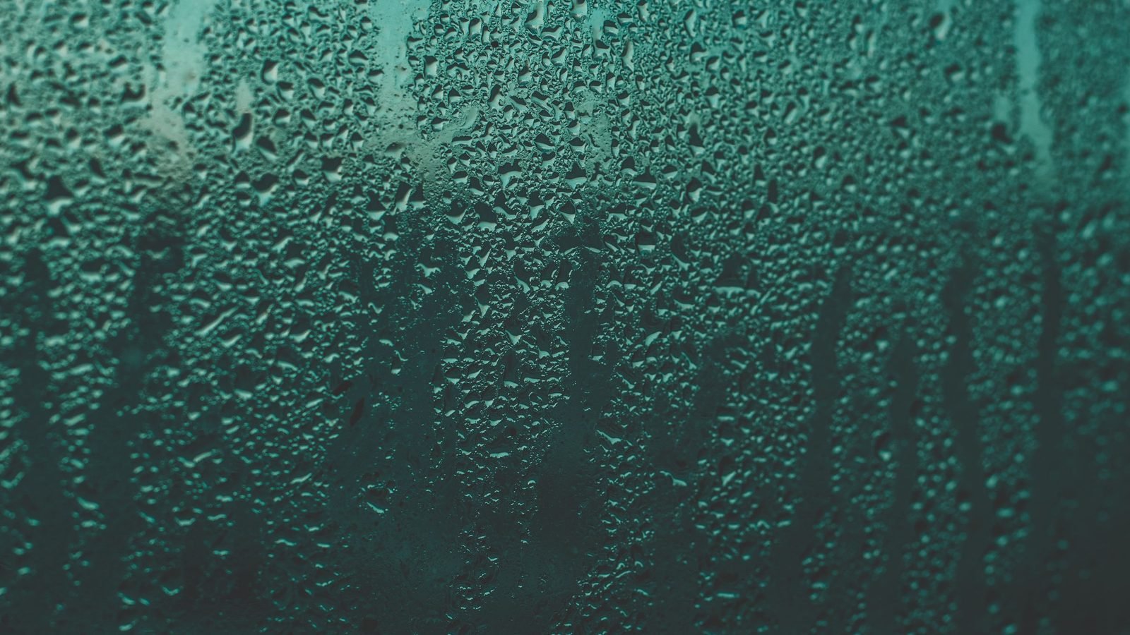 Condensation beading across a cold glass pane