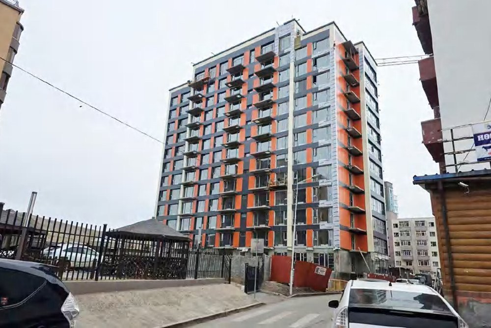 A multi-storey apartment residence in Mongolia with repeated dark-framed casement window bays