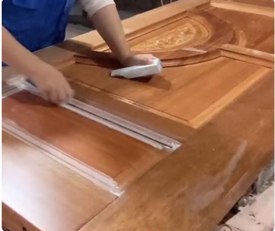 Worker hand-finishing a door leaf — wiped down and checked before packing