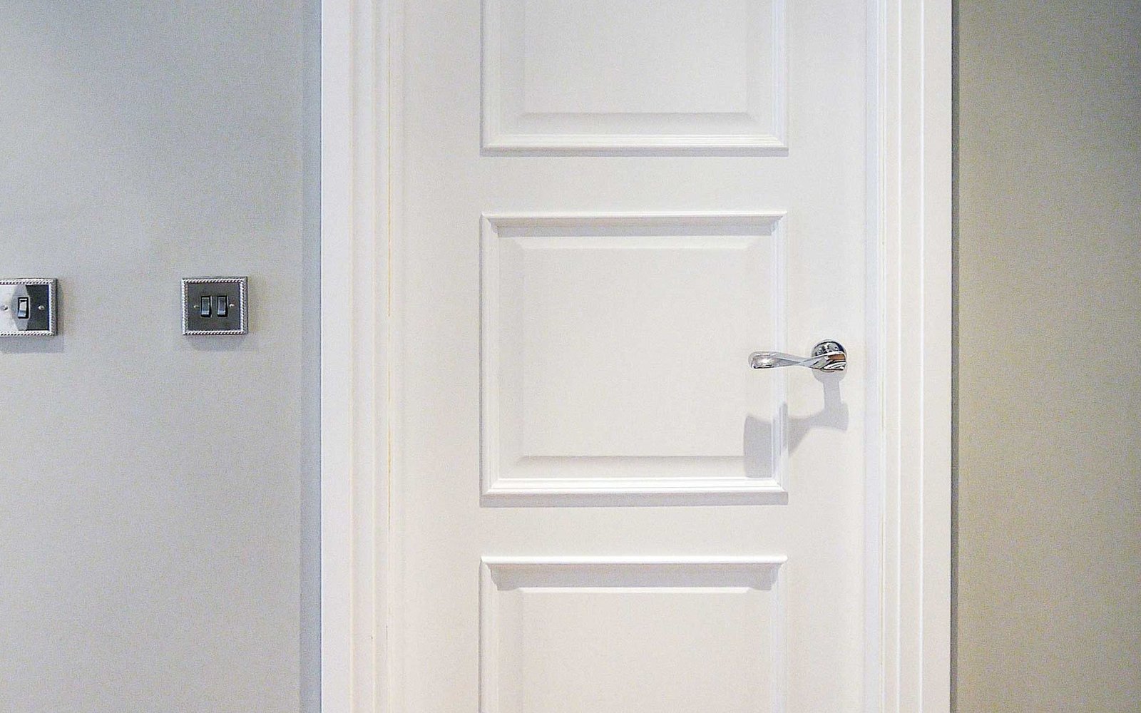 White glazed entrance with sidelights on a residential facade