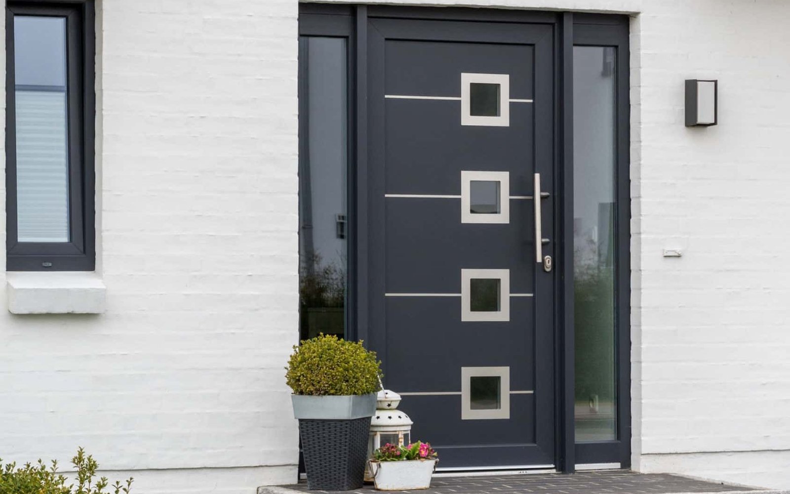 Dark glazed door with the handle set on a white facade