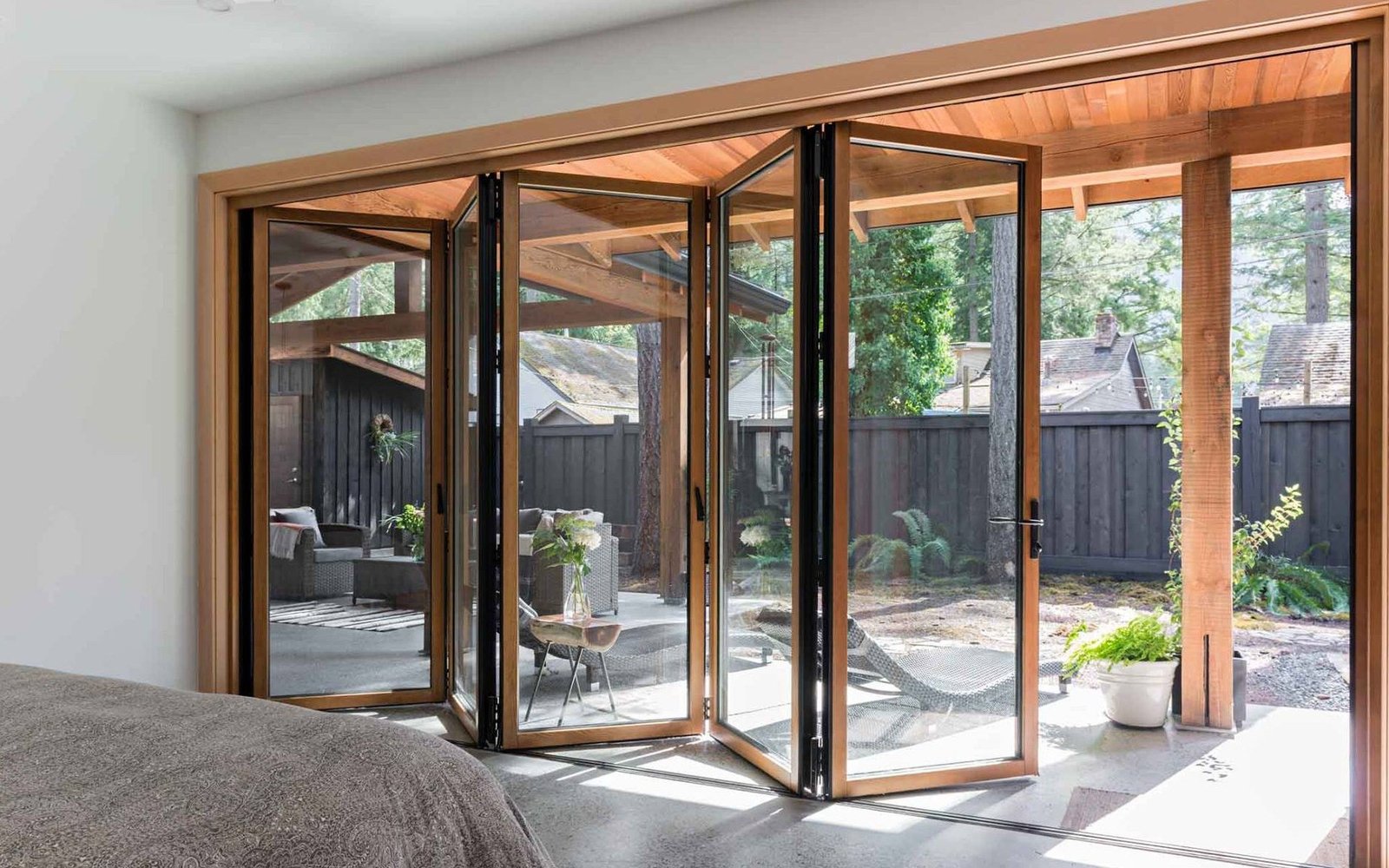 Timber folding doors opening to a planted tropical verandah