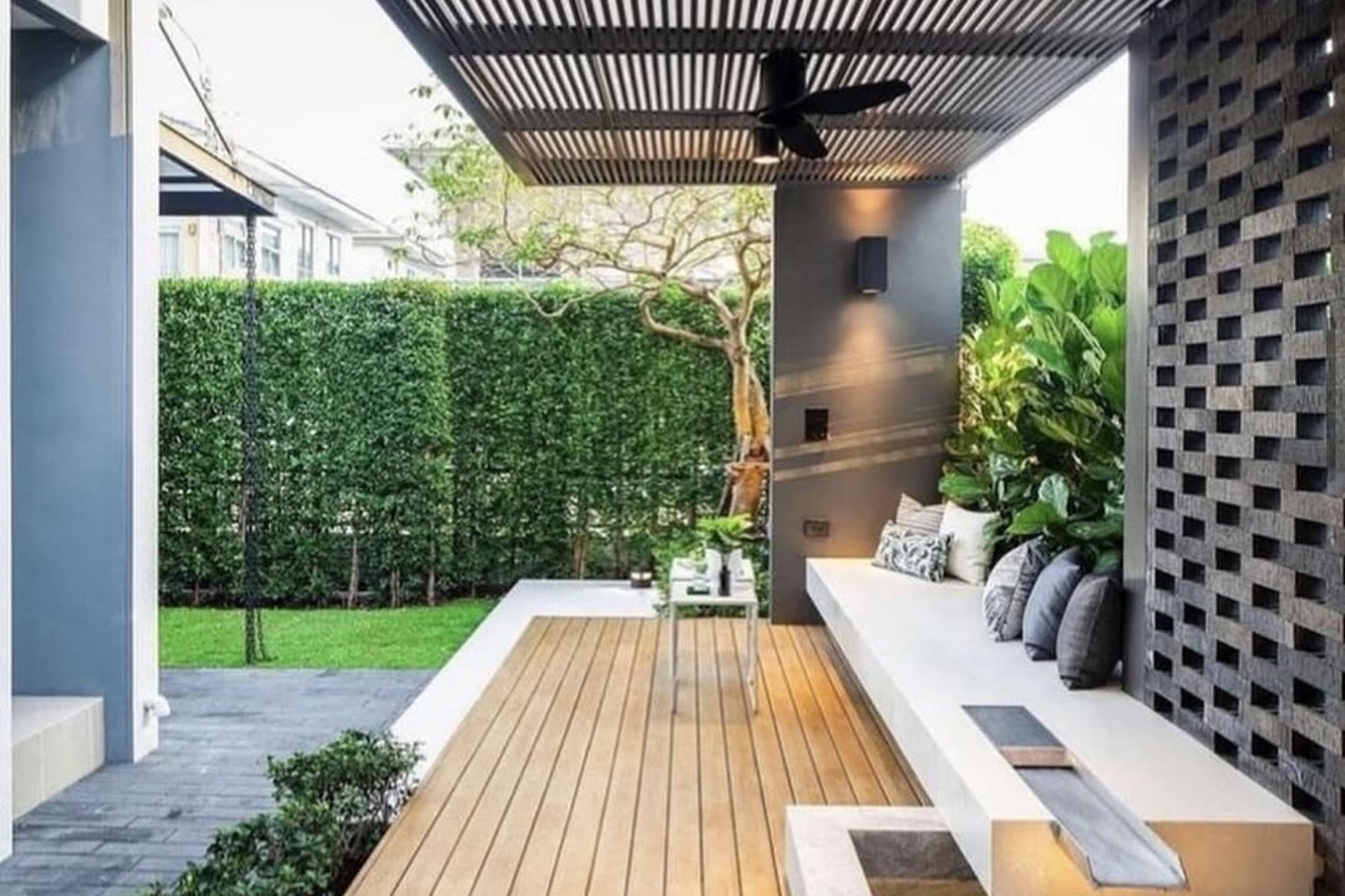 White louvered pergola over a paved terrace beside a modern house