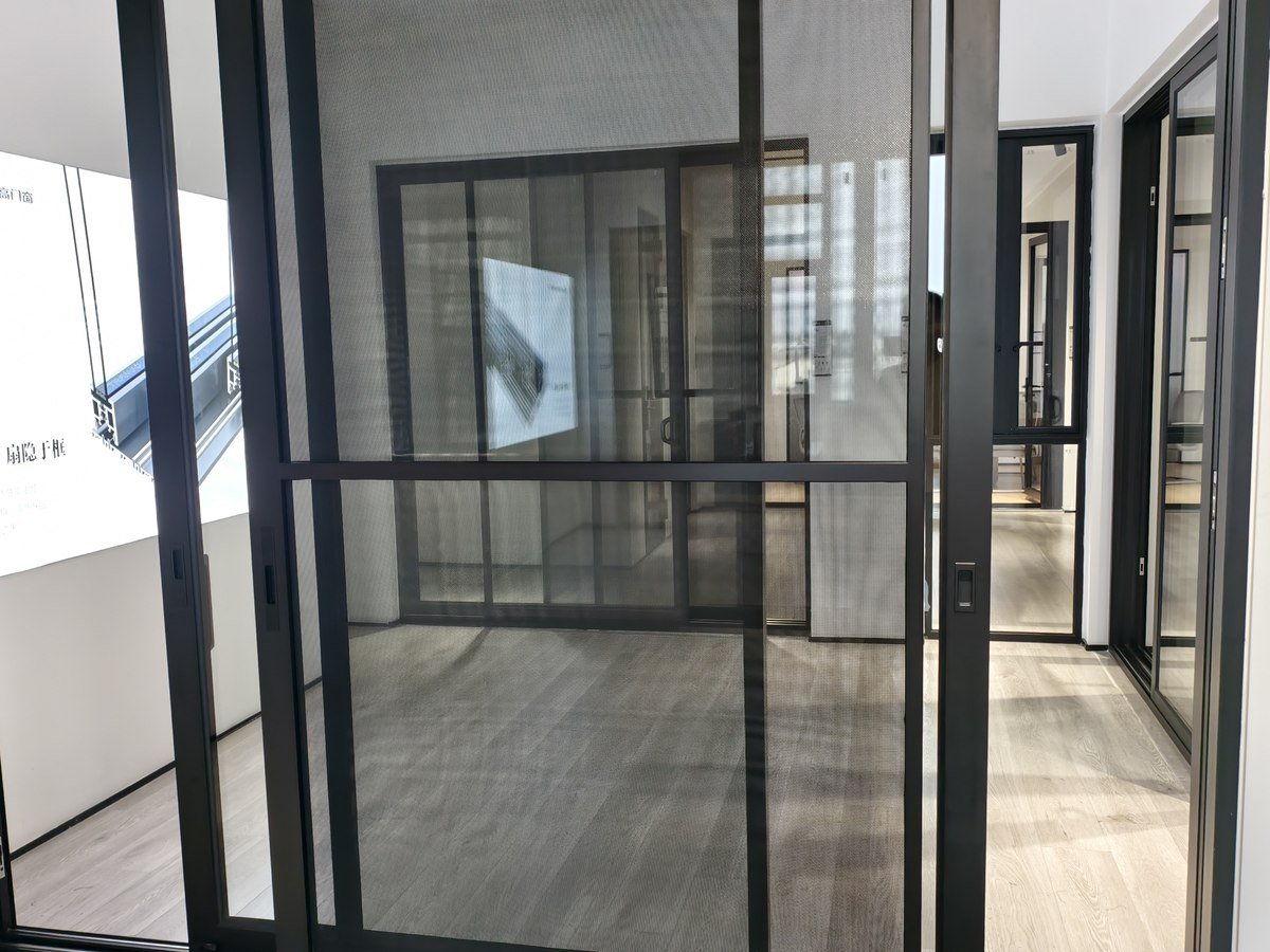 Framed glass partition screen dividing a bright interior