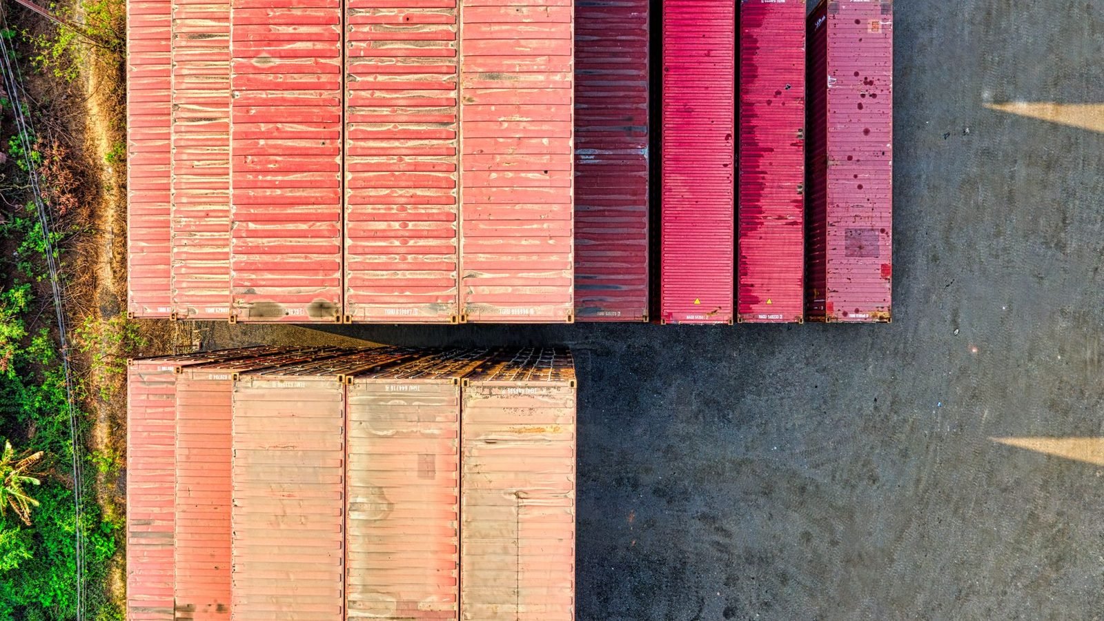 Red containers stacked on gravel, seen from directly above