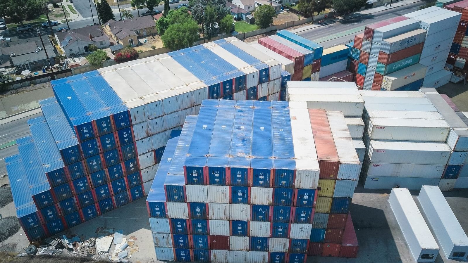 Stacks of cargo containers in a yard, seen from a drone
