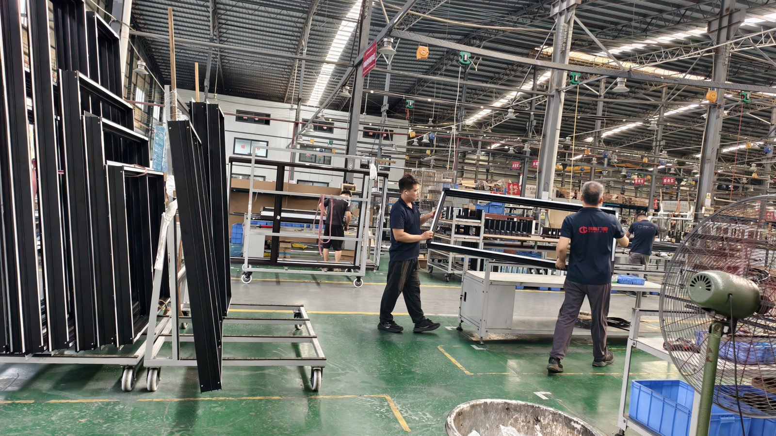 Worker packing a black window frame at the packing station