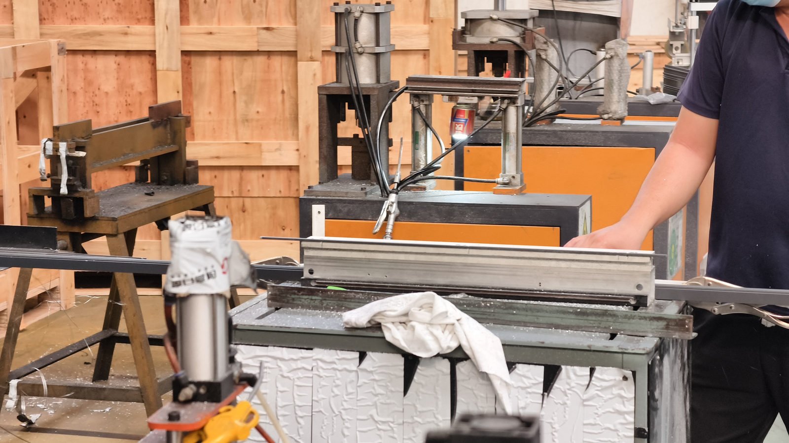 Double-head saw cutting an aluminium profile to length with swarf visible