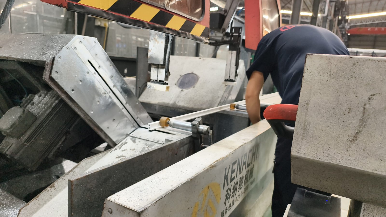 End-milling machine cutting the end face of an aluminium profile with swarf flying