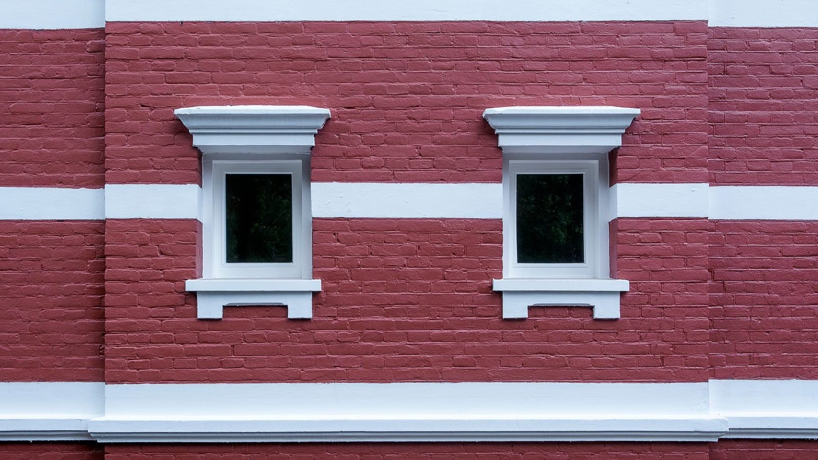 Two small windows set in a red brick wall, the openings counted separately