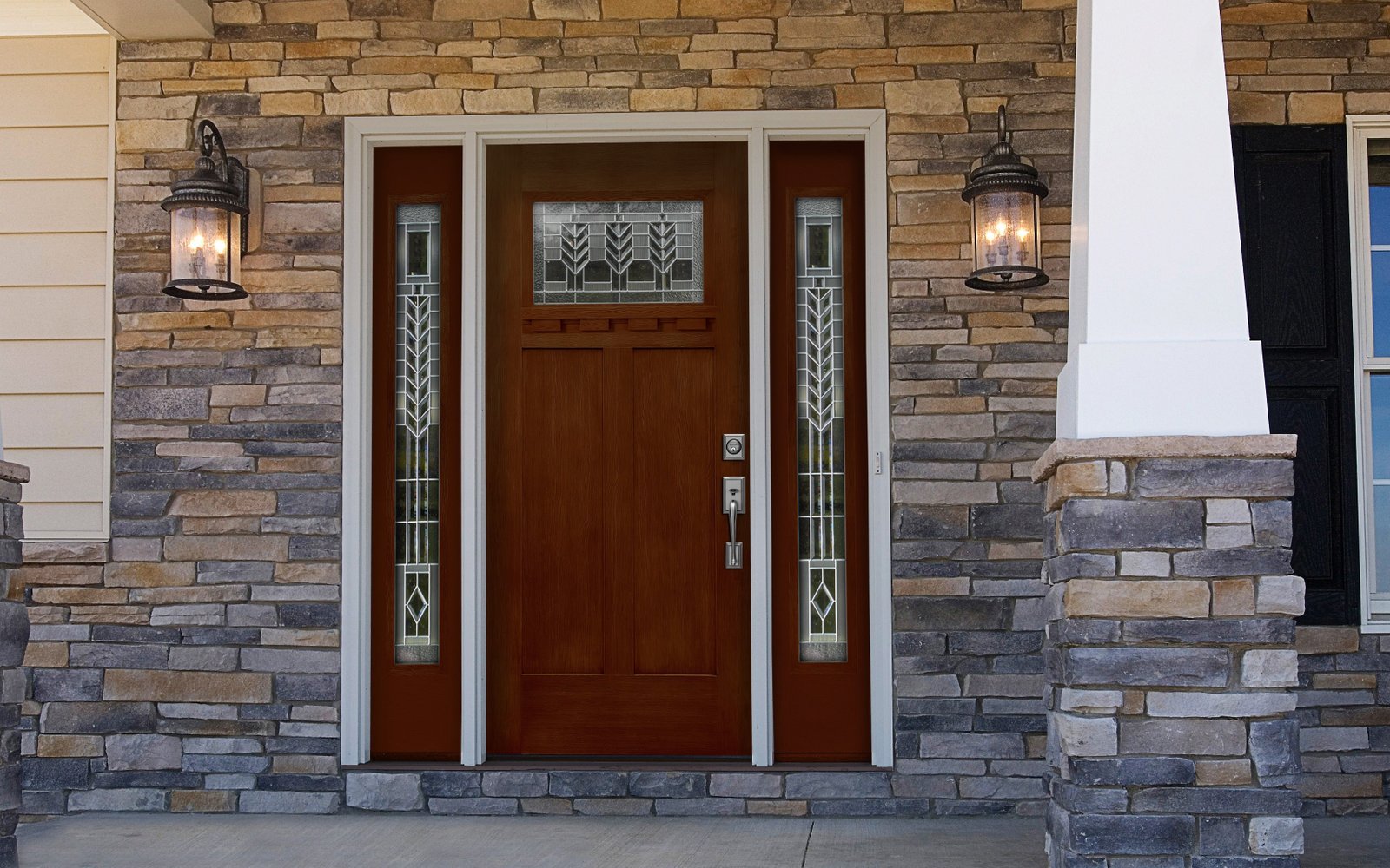 Timber front door with decorative glazing on a stone facade