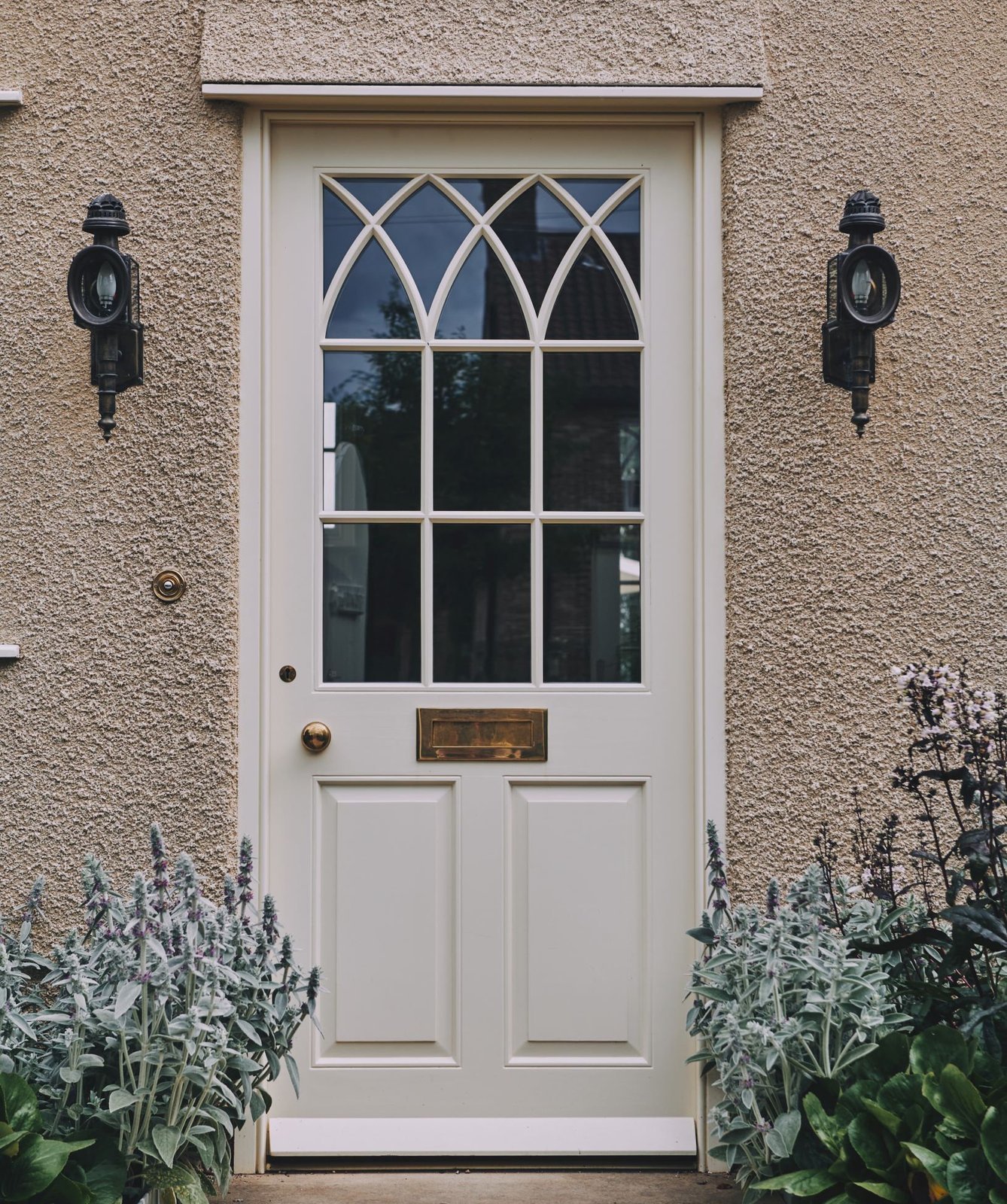 Tall arched glazed door on a brick residence