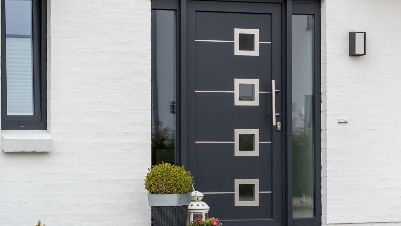 Dark glazed door with the handle set on a white residence
